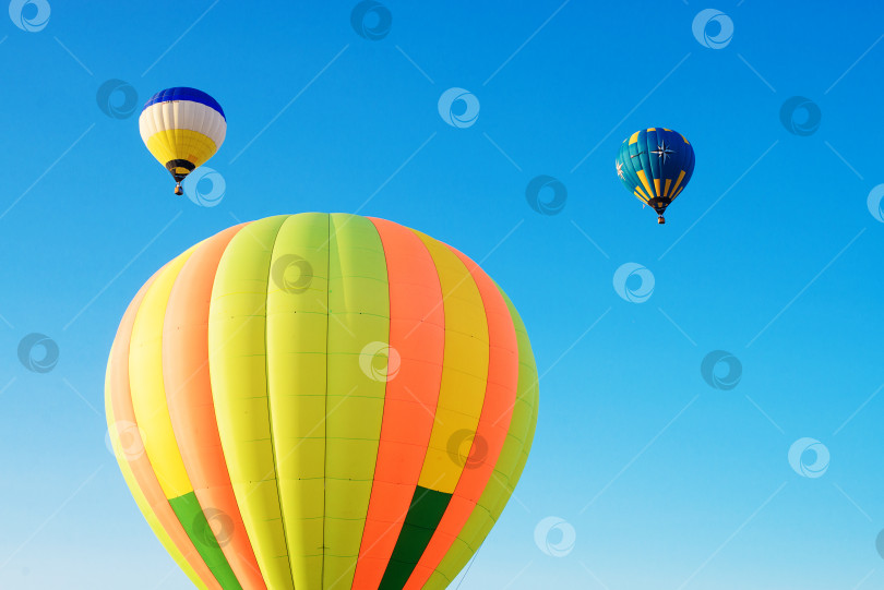 Скачать Разноцветные воздушные шары парят в утреннем голубом небе. фотосток Ozero