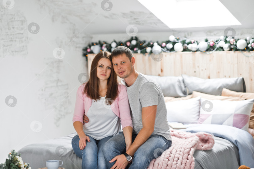 Скачать Муж и жена обнимаются на фоне рождественских украшений 1 фотосток Ozero