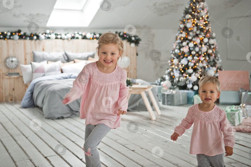 Скачать Маленькие девочки бегают по украшенному к Рождеству дому 2065 года. фотосток Ozero