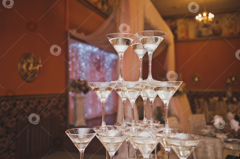 Скачать Пирамида из бокалов для шампанского на фоне праздничного зала 2113 фотосток Ozero