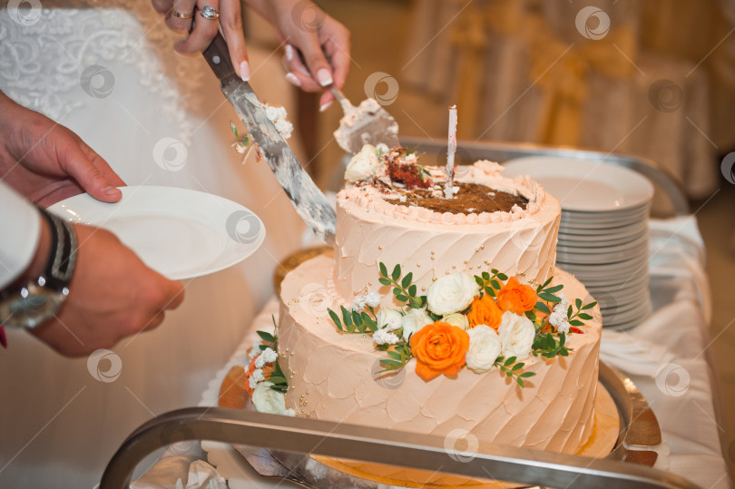 Скачать Процесс разрезания вкусного праздничного торта, украшенного цветами. фотосток Ozero