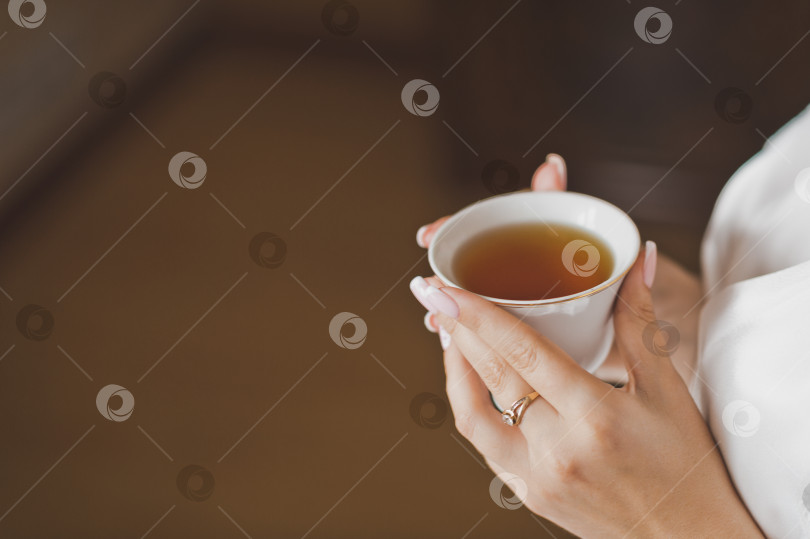 Скачать Маленькая чашка чая в руках красивой девушки утром 2152 года. фотосток Ozero