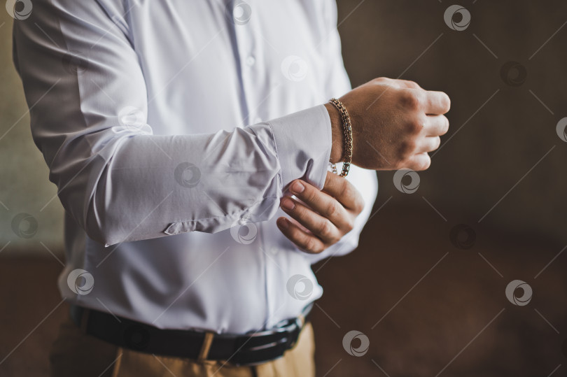 Скачать Мужчина застегивает рукав белоснежной рубашки 2219. фотосток Ozero