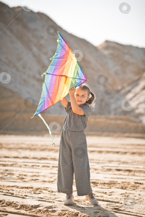 Скачать Ребенок запускает радужного воздушного змея 3347. фотосток Ozero