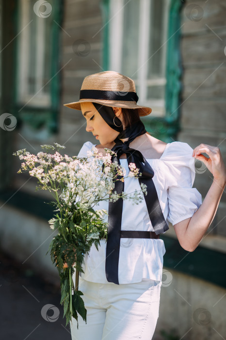 Скачать Девушка в шляпке и белой блузке прогуливается на фоне старого ву фотосток Ozero