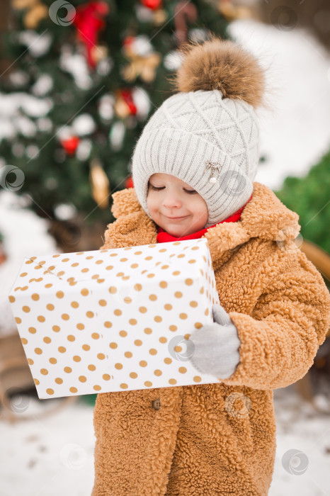 Скачать Счастливая девушка с большим подарком в руках на фоне морозного фотосток Ozero