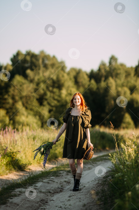 Скачать Деревенская рыжеволосая девушка идет по сельской дороге летом 3287 года. фотосток Ozero