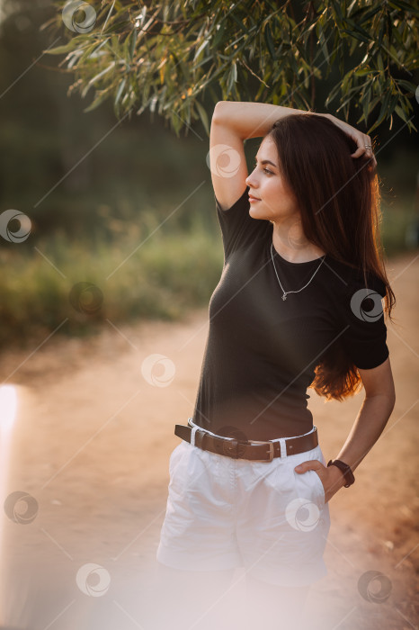 Скачать Юная красавица прогуливается под лучами летнего солнца по лугам фотосток Ozero