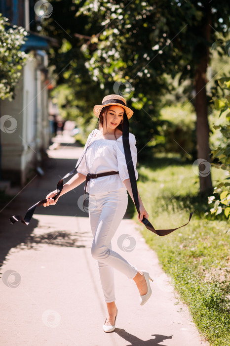 Скачать Молодая девушка в шляпке на фоне цветущих улиц города фотосток Ozero