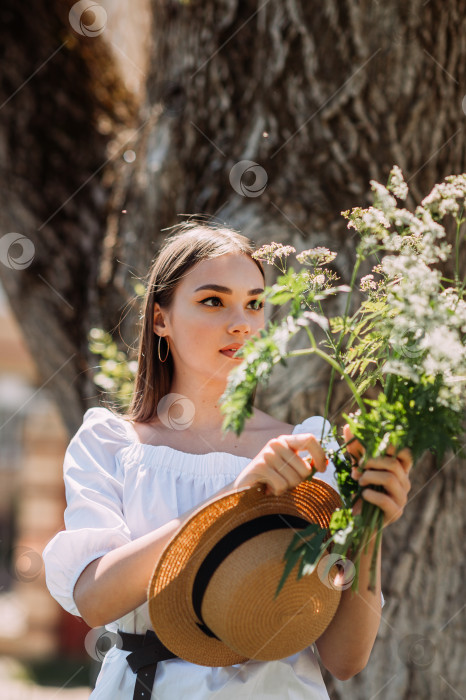 Скачать Молодая девушка в белом платье и шляпке на летней прогулке 3555. фотосток Ozero