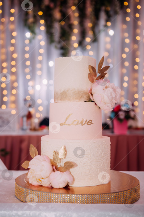 Скачать Оригинальный высокий свадебный торт, украшенный цветами и листьями 3812. фотосток Ozero