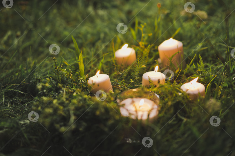 Скачать Горящие свечи на зеленой траве 2421. фотосток Ozero