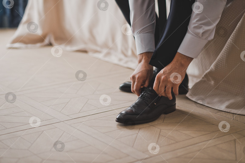 Скачать Мужские руки носят обувь 2410. фотосток Ozero