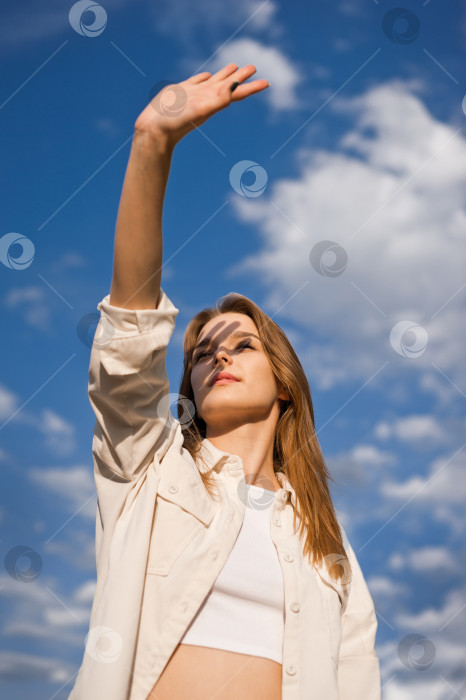 Скачать Портрет молодой девушки на фоне голубого неба и облаков 3695. фотосток Ozero