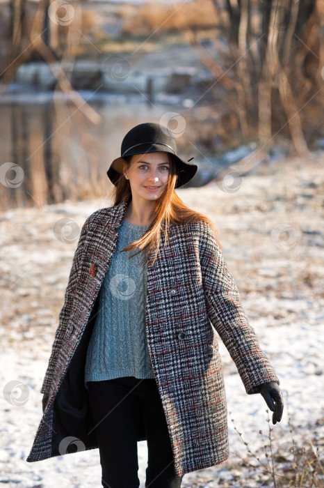 Скачать Весенняя фотография девушки в шапке и сером пальто на фоне тающего снега 3478. фотосток Ozero