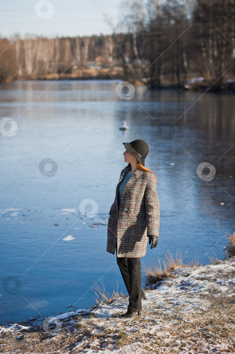 Скачать Весенняя фотография девушки в шапке и сером пальто на фоне тающего снега 3479. фотосток Ozero