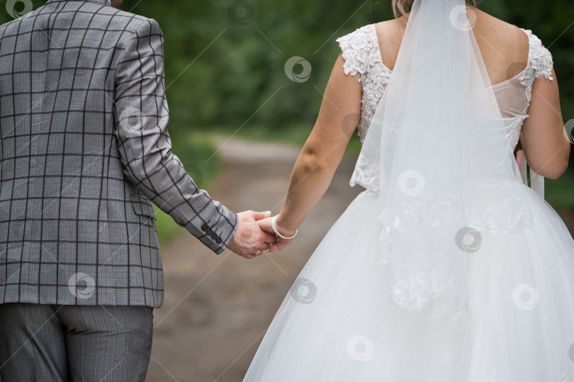 Скачать Жених и невеста, держась за руки, уходят вдаль 3139. фотосток Ozero
