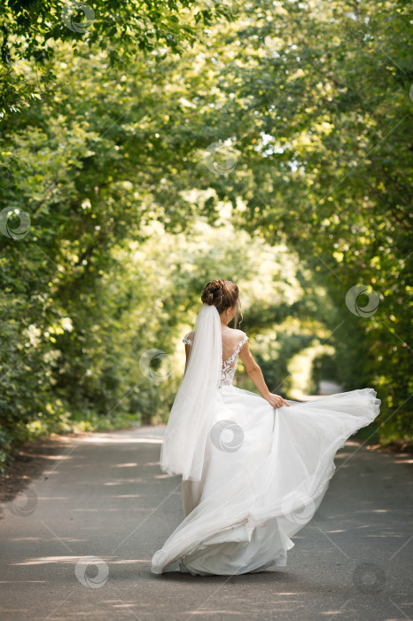 Скачать Невеста в шикарном платье кружится в туннеле из растений 3197. фотосток Ozero