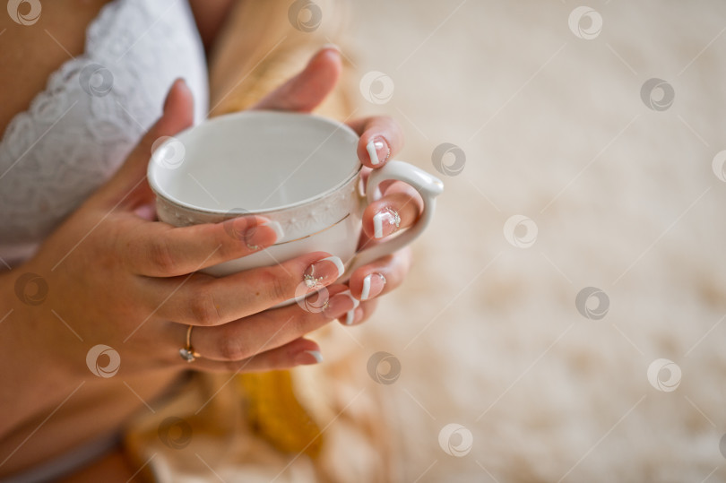 Скачать В руках девушки белая чайная чашка 2518. фотосток Ozero