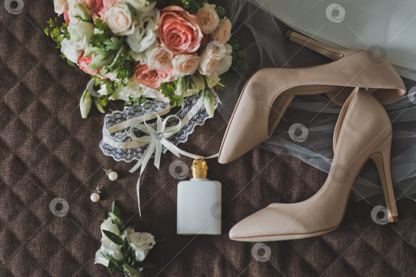 Скачать Свадебный букет и вещи невесты лежат на коричневой поверхности фотосток Ozero
