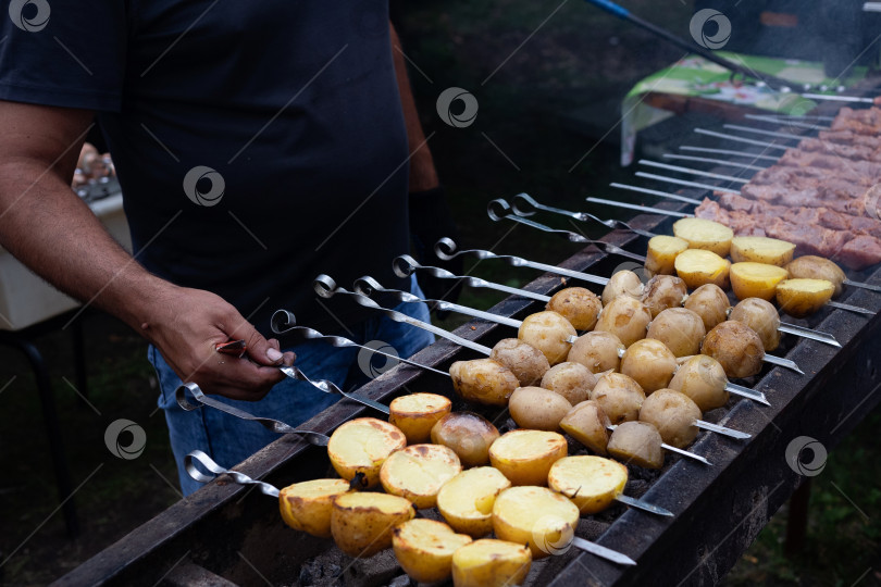 Скачать Готовим шашлык на металлической шпажке и овощи гриль. Мясо и овощи гриль. Вкусная уличная еда. фотосток Ozero