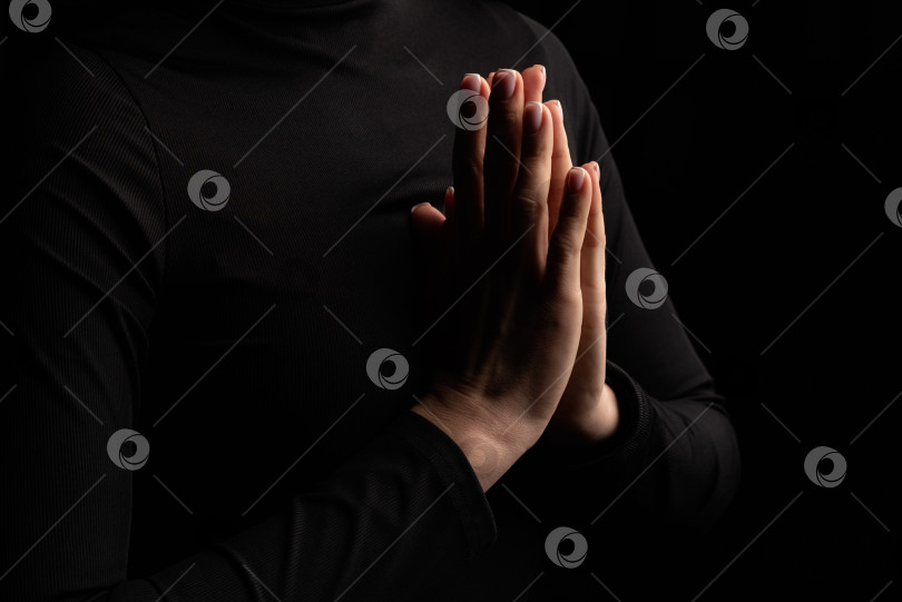 Скачать Женские руки, сложенные в молитвенном жесте на темном фоне крупным планом фотосток Ozero