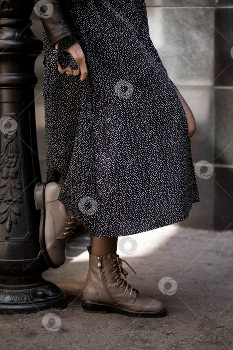 Скачать крупным планом ноги женщины в кожаных сапогах и длинной юбке, стоящей на улице фотосток Ozero