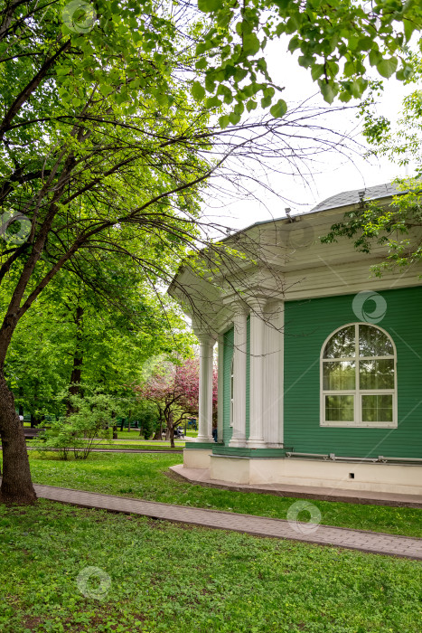 Скачать Выкрашенный в зеленый цвет фасад деревянного дома в летнем парке фотосток Ozero