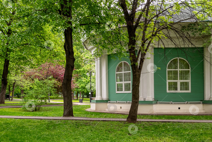 Скачать деревянный коттедж в парке среди зеленых деревьев фотосток Ozero