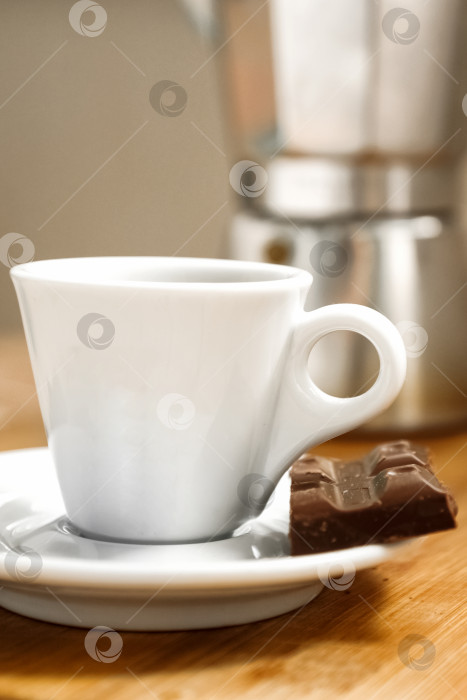 Скачать Белая чашка кофе эспрессо с кусочком шоколада на тарелке, крупным планом фотосток Ozero