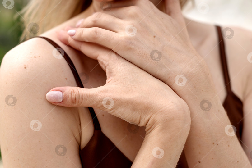 Скачать женщина кладет руку на свое обнаженное плечо крупным планом фотосток Ozero