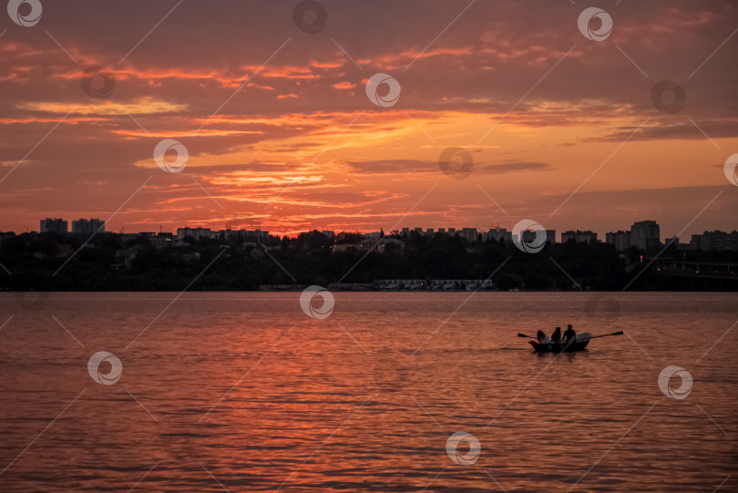 Скачать люди катаются на лодке по озеру на закате летним вечером фотосток Ozero