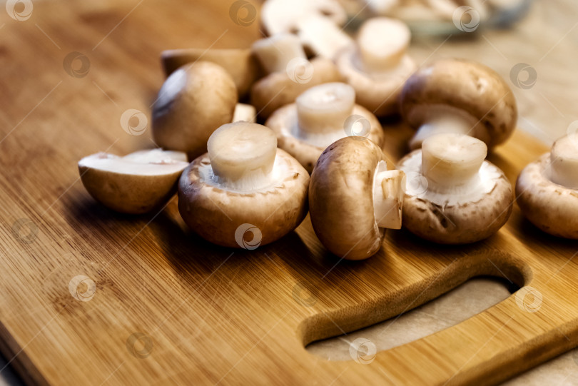 Скачать Свежие шампиньоны грибы на деревянной разделочной доске фотосток Ozero