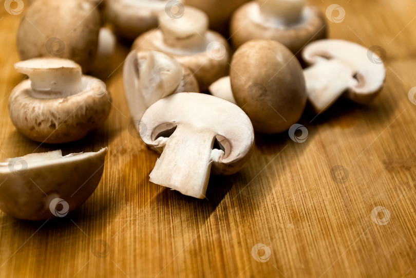 Скачать Свежие шампиньоны грибы на деревянной разделочной доске фотосток Ozero