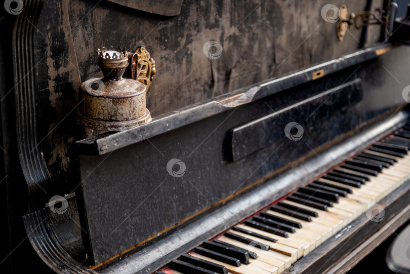 Скачать разрушенное пианино с ржавыми подсвечниками и потрепанной клавиатурой со сломанными клавишами крупным планом выборочный фокус фотосток Ozero