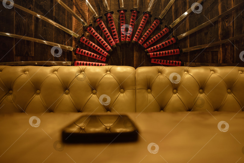Скачать интерьер ресторана с кожаным диваном и восточными украшениями, висящими на стене фотосток Ozero