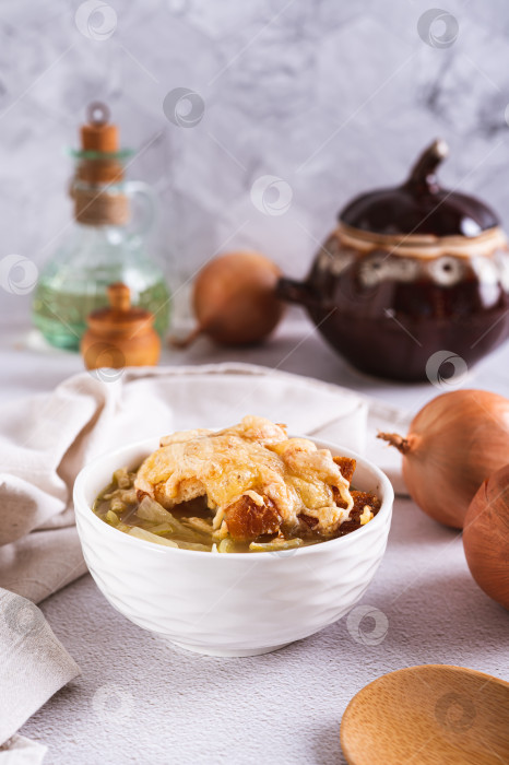 Скачать Домашний луковый суп с гренками и сыром в миске на столе вертикальный вид фотосток Ozero