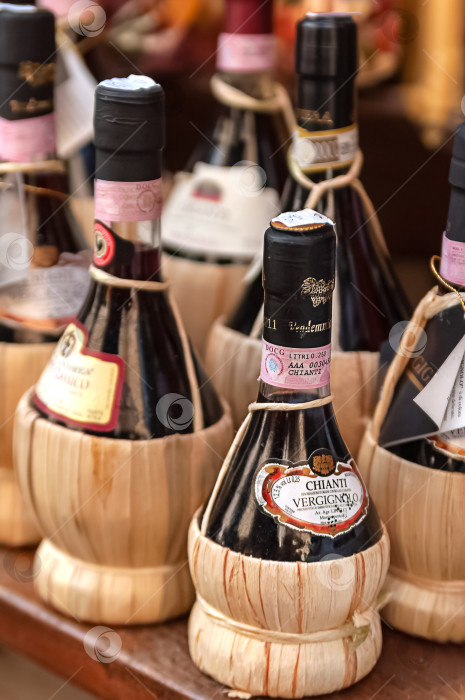 Скачать 13 мая 2013 года, Италия, Милан - Ряды плетеных бутылок вина Кьянти фотосток Ozero