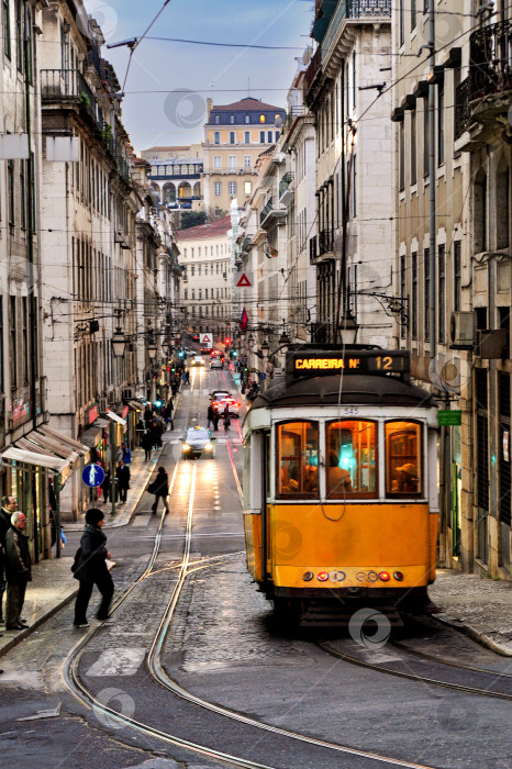 Скачать 03 января 2012 года, Лиссабон, Португалия - Движение трамвая на улице города Лиссабон вечером фотосток Ozero