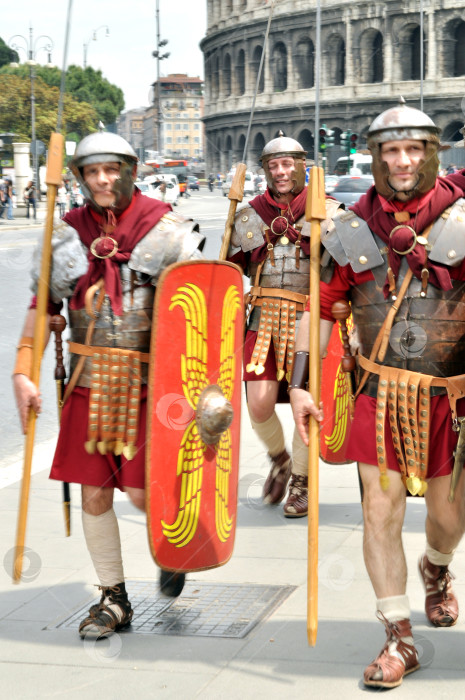Скачать 11.05.2010 - Рим, Италия - группа мужчин, одетых как римские легионеры, прогуливается у стен Колизея фотосток Ozero