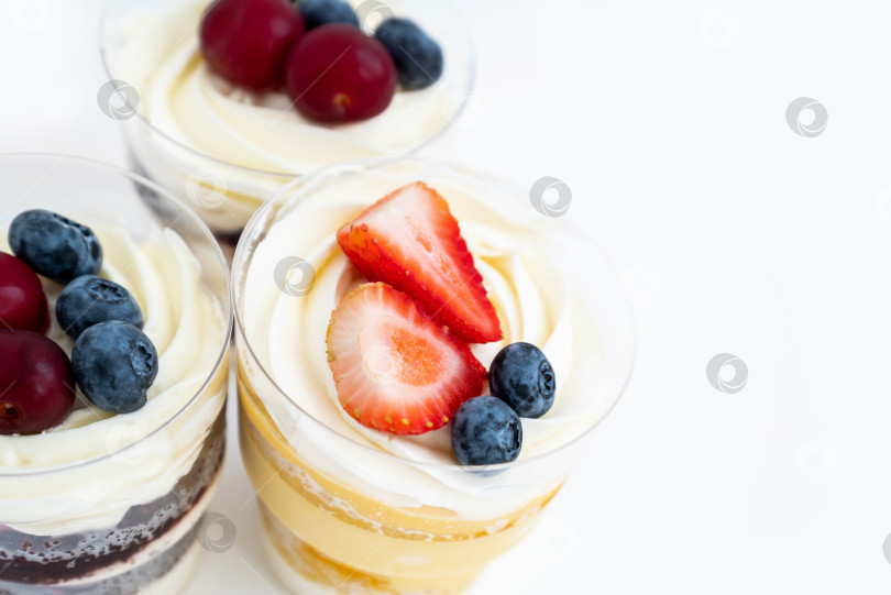 Скачать Вид сверху на сладкие пирожные с кремом и свежими ягодами фотосток Ozero