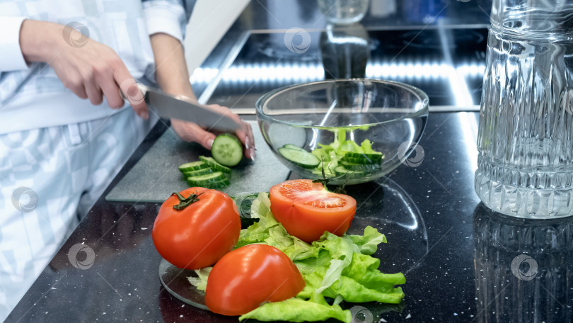Скачать Процесс приготовления овощного салата. Нарезка огурцов и помидоров. Здоровое веганское питание и образ жизни фотосток Ozero
