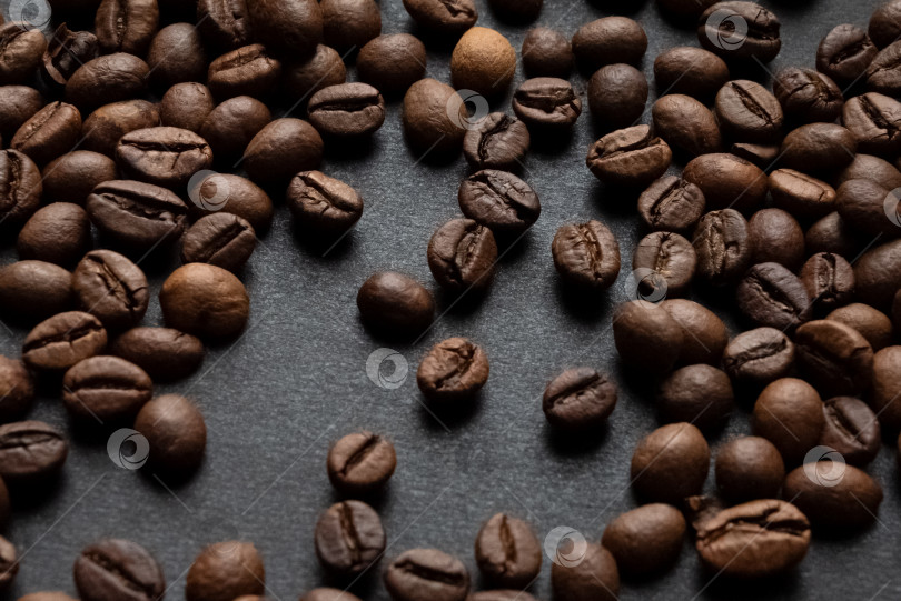 Скачать Обжаренные кофейные зерна, разбросанные по темному фону фотосток Ozero