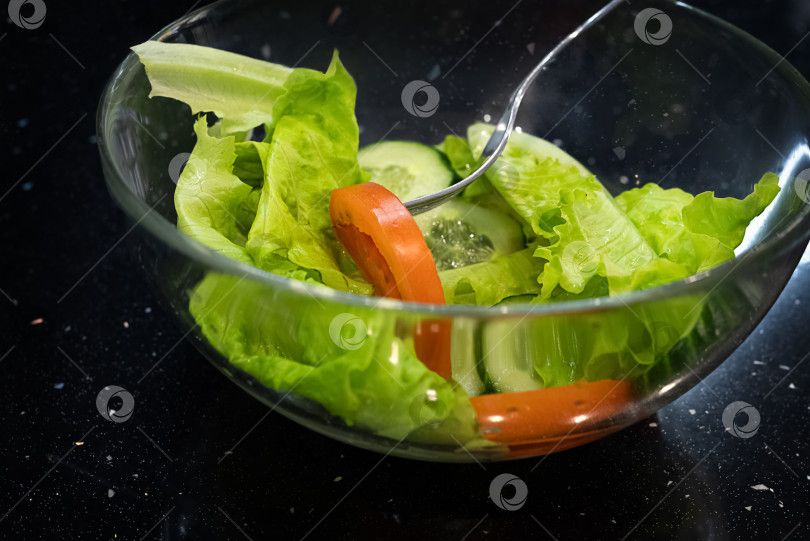 Скачать Крупный план стеклянной миски с зеленым салатом и ломтиками помидоров. Концепция диеты и здорового питания фотосток Ozero