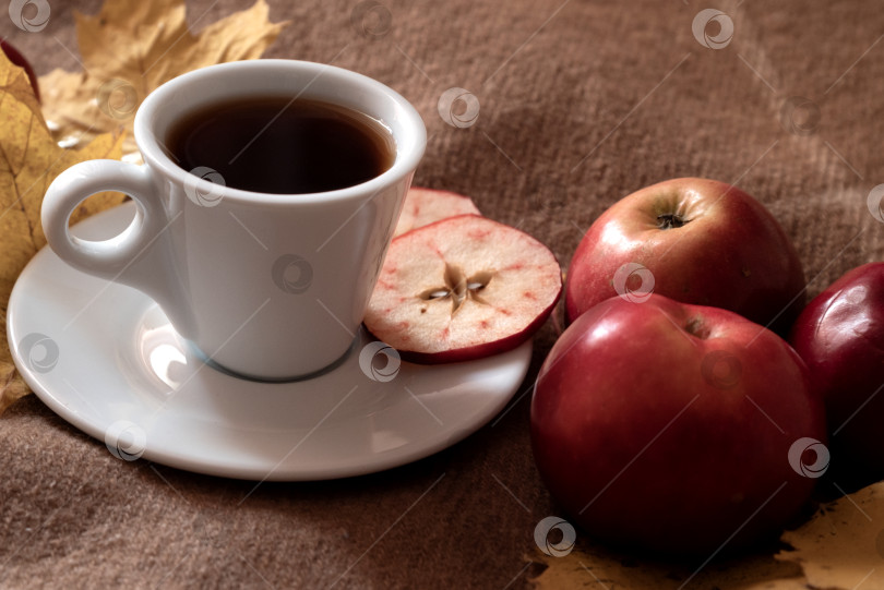 Скачать Горячий травяной фруктовый чай в чашке и спелые красные яблоки крупным планом фотосток Ozero