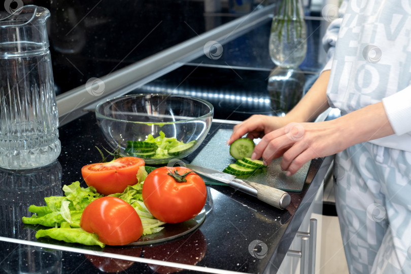 Скачать Процесс приготовления овощного салата. Нарезка огурцов и помидоров. Здоровое веганское питание и образ жизни фотосток Ozero