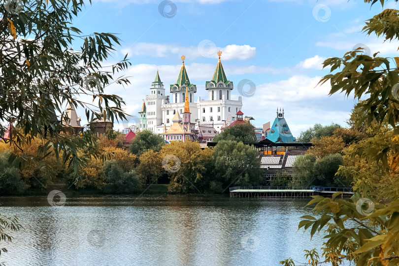 Скачать архитектурный ансамбль в русском стиле среди пожелтевших осенних деревьев отражается в воде озера фотосток Ozero