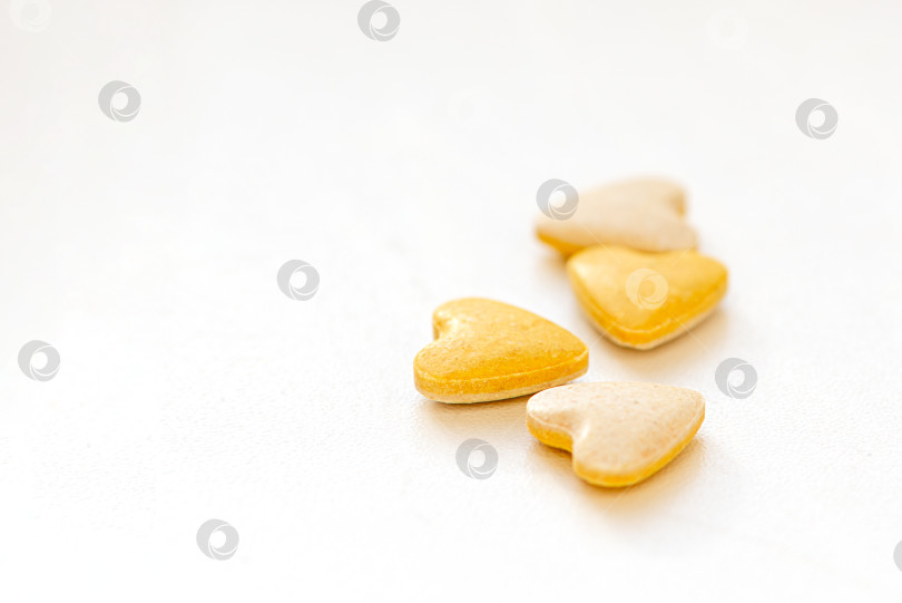 Скачать Желтые витаминные таблетки в форме сердца на белом фоне фотосток Ozero