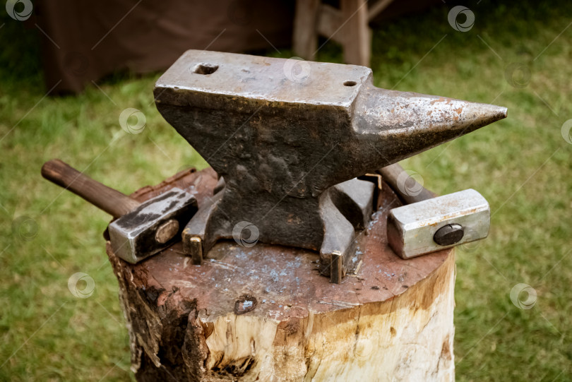 Скачать наковальня и молоток на деревянном бруске в кузнице фотосток Ozero