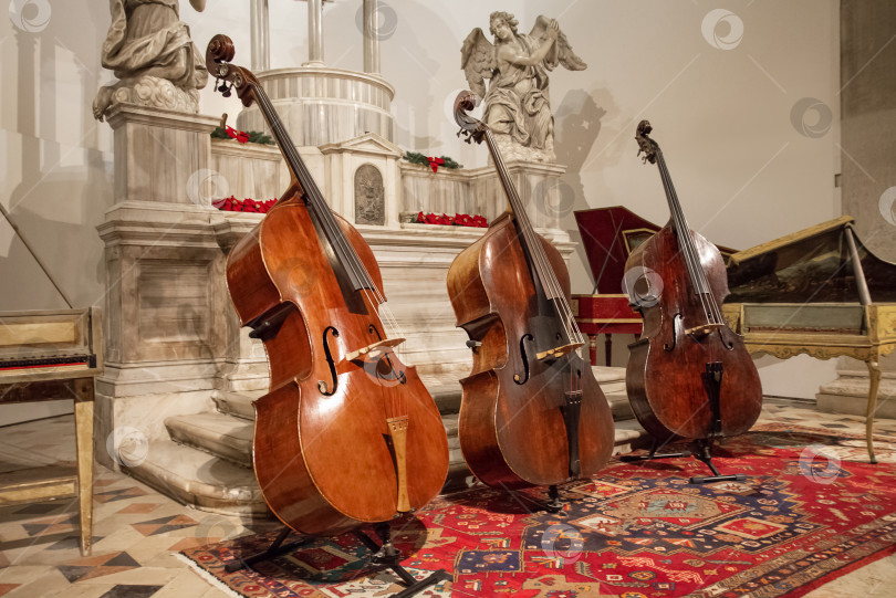 Скачать Три виолончели на сцене, готовые к концерту классической музыки фотосток Ozero